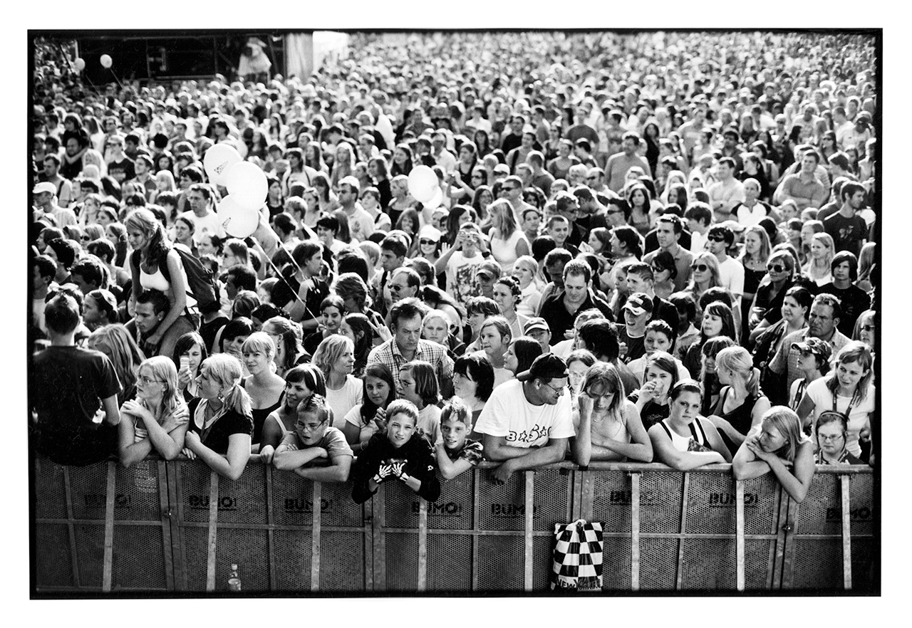 A large crowd of people at an outdoor concert.